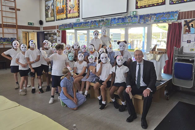 Andy Slaughter (right) with children from the Good Shepherd Primary School in masks they had made 