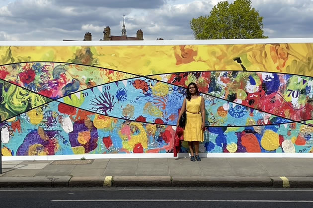 Sangeeta standing in front of the mural 